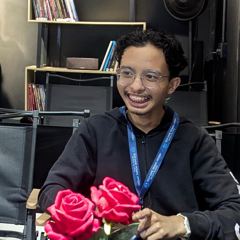 Hazeeq Haikal, smiling in a black hoodie and a Tech Dome Penang intern lanyard